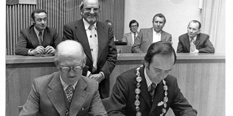 Unterschrift der Verschwisterungsdokumente, 2. Mai 1975 Vlnr: Vorsitzender Dacorum-Council Jack Johnsen(l), Bürgermeister Neu-Isenburg Frey, stehend  Stadtverordnetenvorsteher Karl-Heinz Schäfer